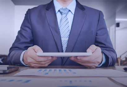 Professionnel en costume tenant une tablette avec documents comptables - Cabinet expertise comptable Tunisie